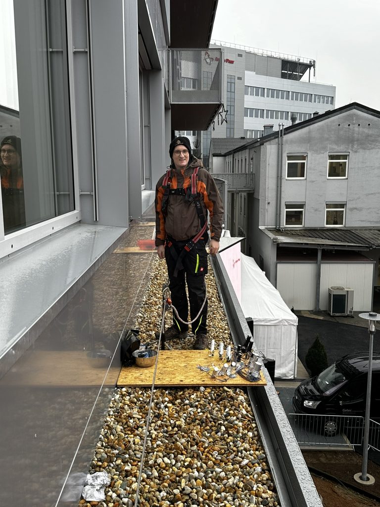 Mitarbeiter von XP-Fire bei Vorbereitungsarbeiten für pyrotechnische Effekte auf einem Gebäudedach.