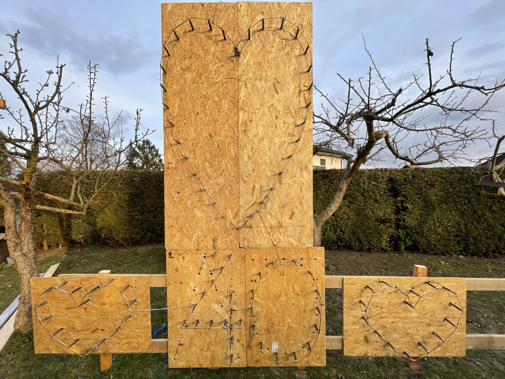 Mehrere herzförmige Lichterbild-Installationen auf Holzplatten für pyrotechnische Inszenierungen.