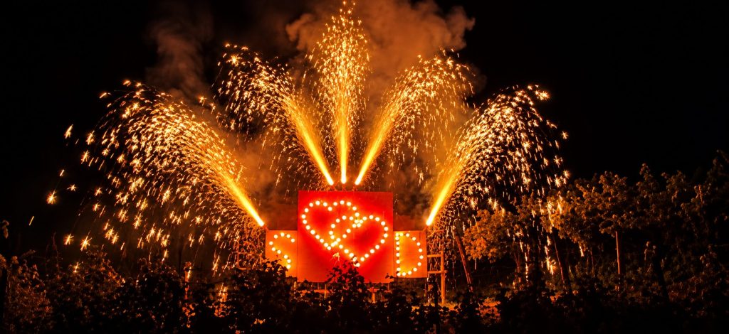 Goldenes Bodenfeuerwerk mit leuchtenden Herzen bei Nacht.