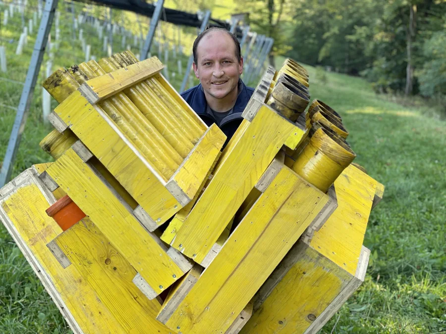 Christian trägt gelbe Feuerwerksgestelle bei den Vorbereitungen.