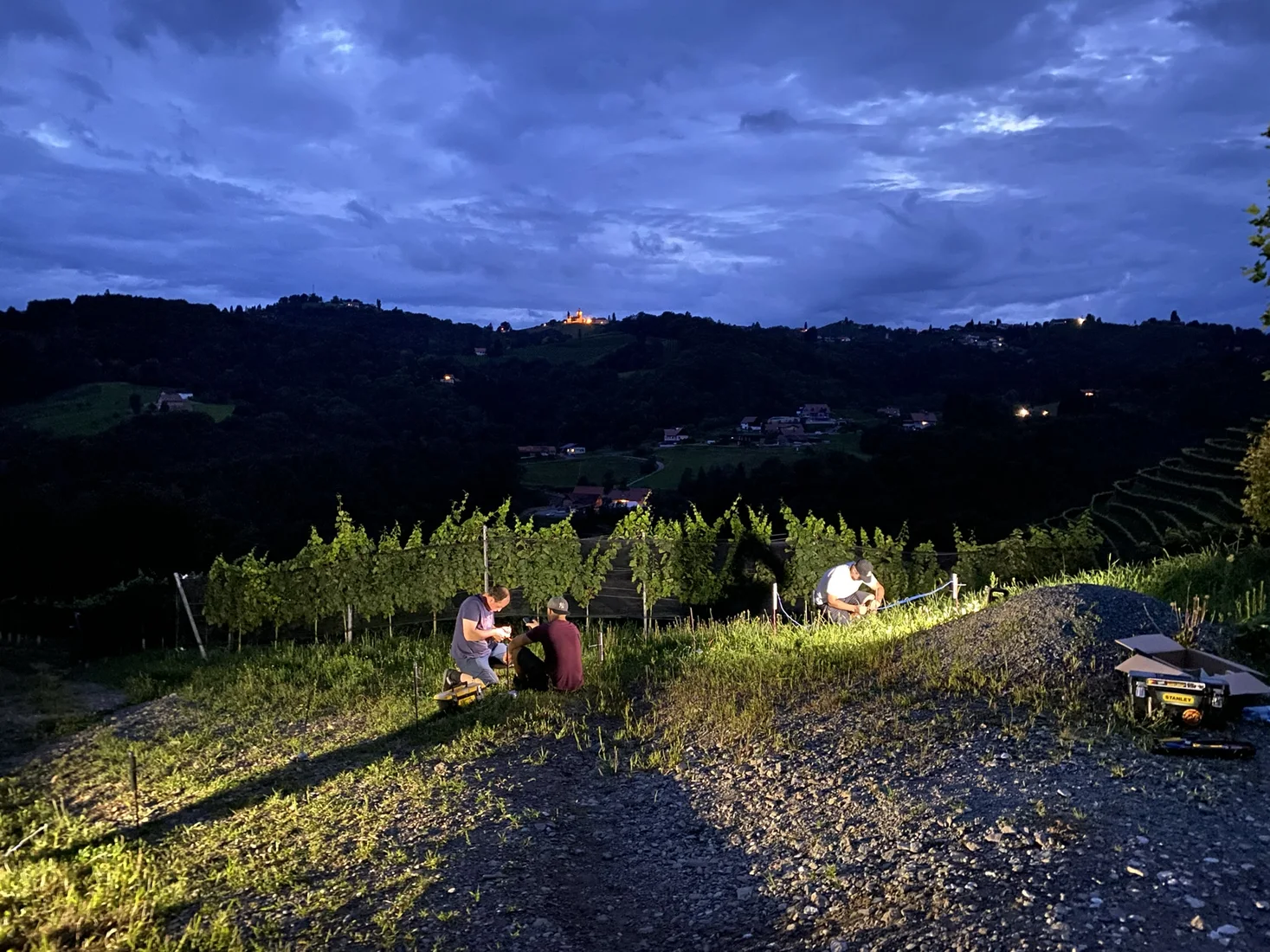 Aufgebautes Feuerwerk und XP-Fire Einsatzteam in den Weinbergen bei Abenddämmerung.