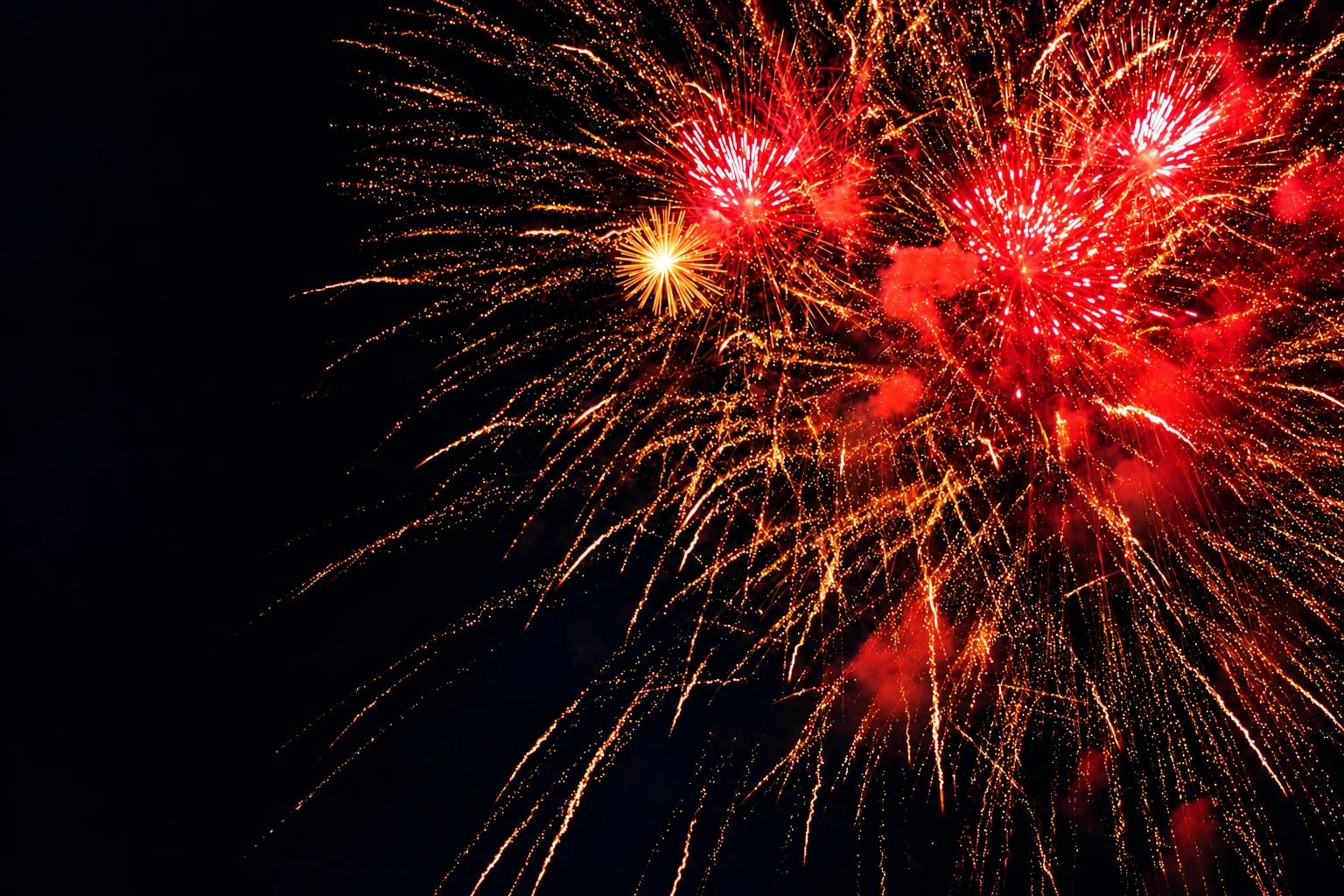 Farbenkräftiges rotes und goldenes Silvesterfeuerwerk