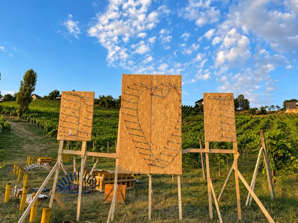 Vorbereitete Lichtbildkonstruktionen und Feuerwerksgestelle in einem Weingarten.